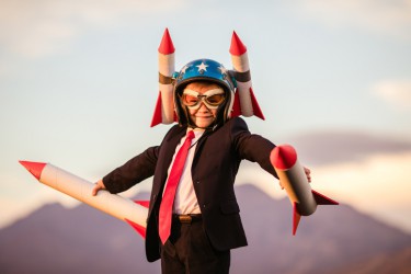Young Business Boy in Helmet Holding Rockets